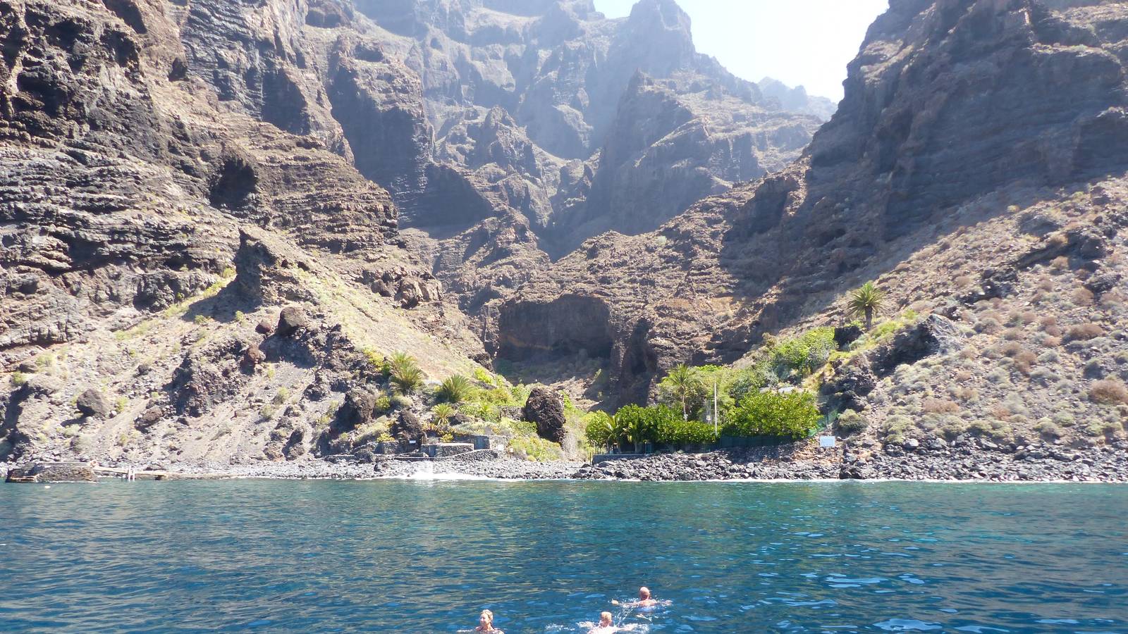 Los Gigantes cliffs and Masca bay from the sea, small beach, swimmers near shore