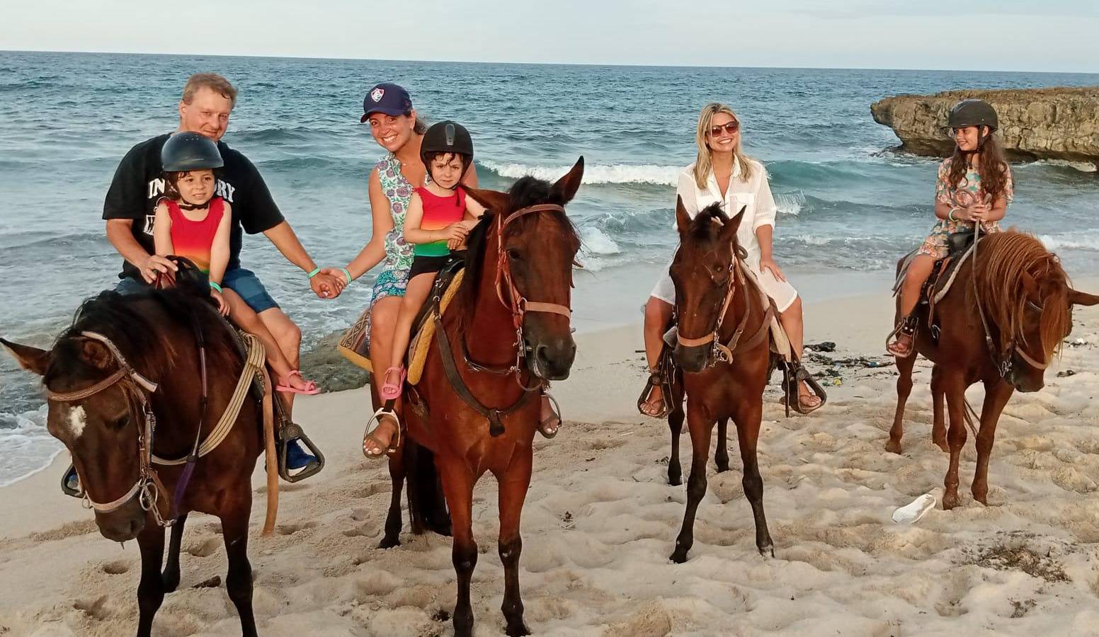 Riders on a windward Aruba beach, with surf behind them