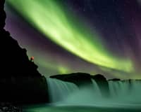 Horseshoe waterfall under green and purple aurora