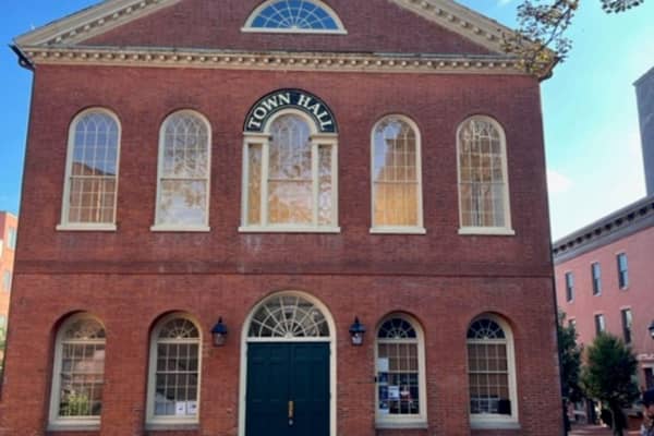 A red-brick hall with arched windows in daylight