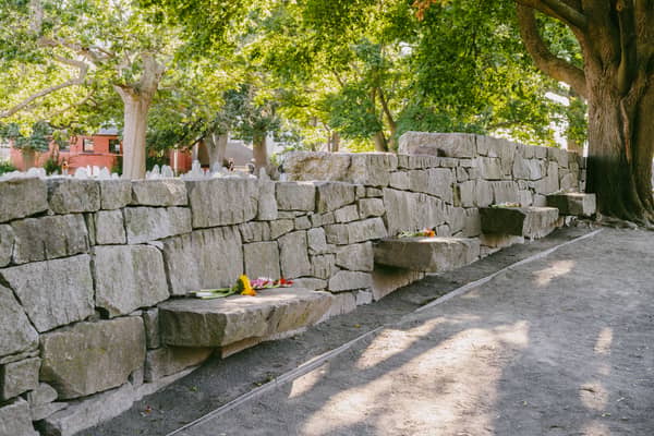The low stone bench wall of the Witch Trials Memorial