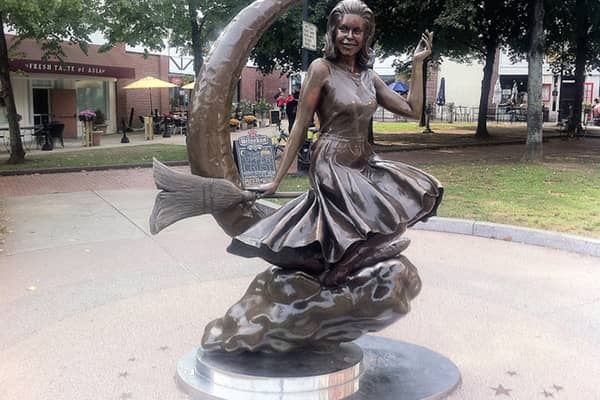A bronze statue of a woman riding a crescent moon