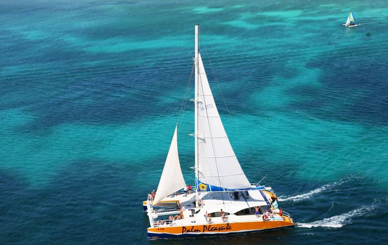 Catamaran under sail in turquoise water