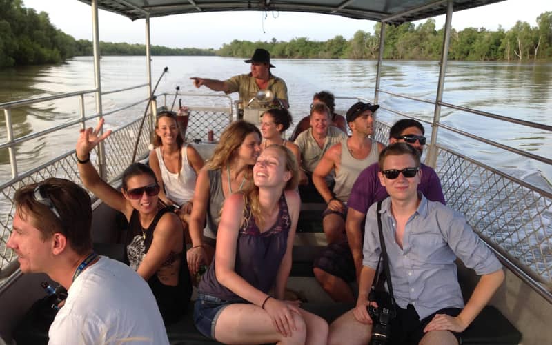 Passengers laughing on a boat, the guide pointing