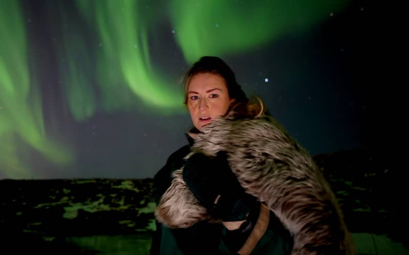 Woman holding a fur cloak, Viking-costume portrait under aurora