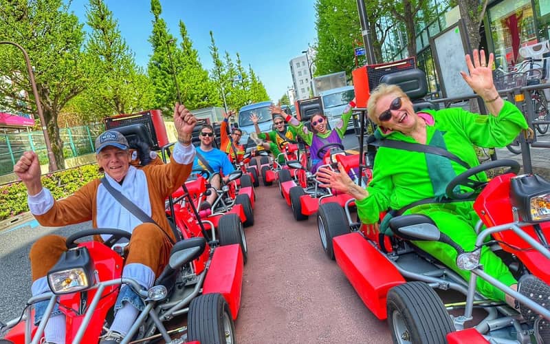 A line of red karts on a wide avenue with spring greenery