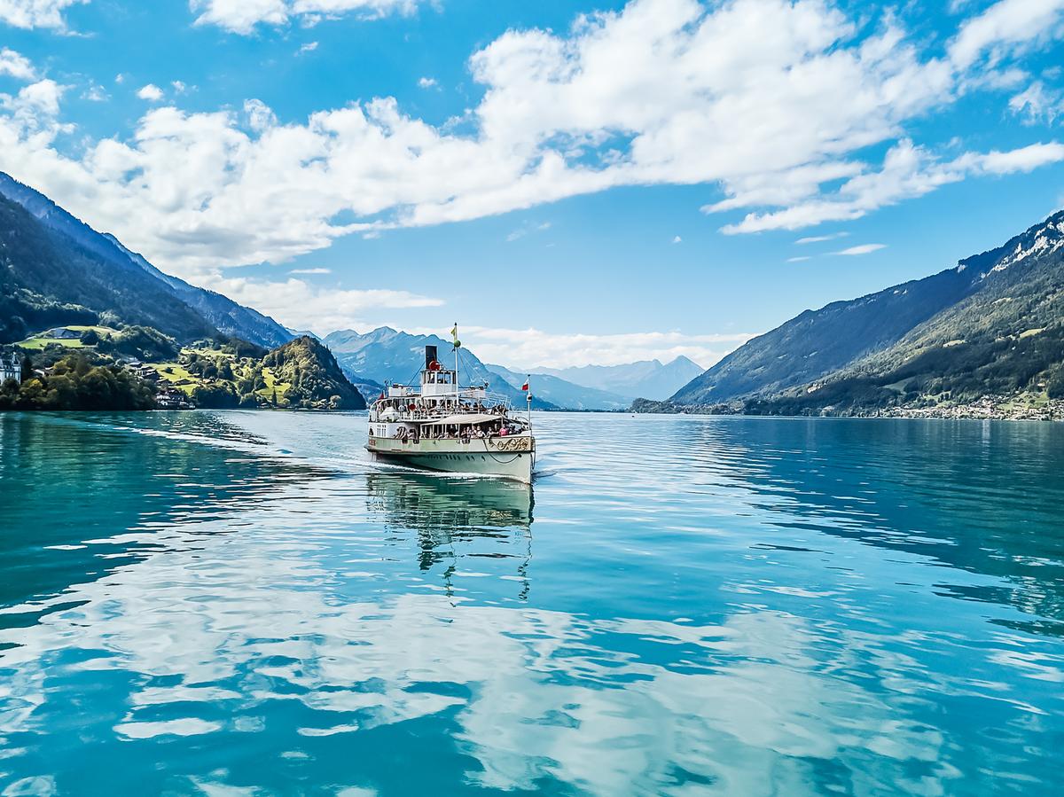 Türkisfarbener Brienzersee und Bergdörfer vom Schiff aus