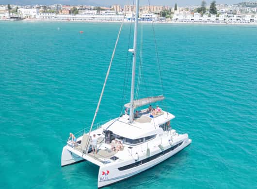 Zittende passagiers die genieten van het uitzicht vanaf de catamaran
