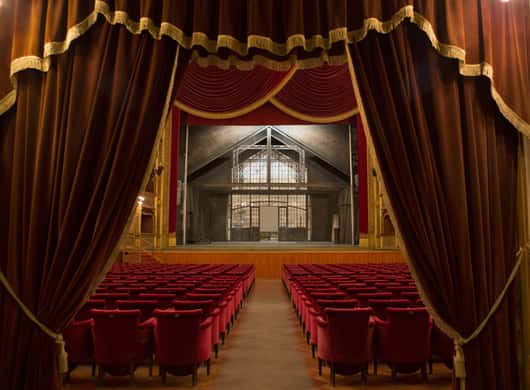 Rijen rode stoelen en balkons in het operahuis van Palermo