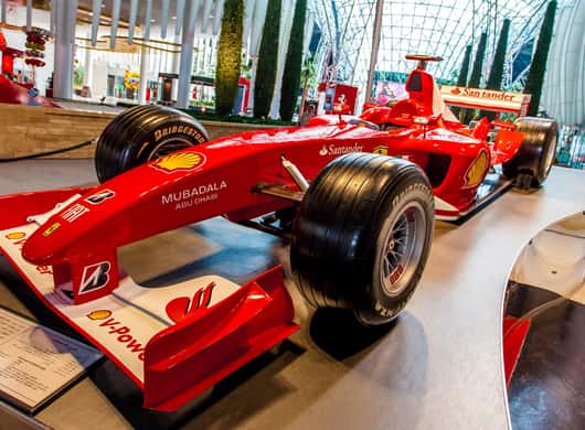 Bezoekers die een rode Ferrari bewonderen in het museum