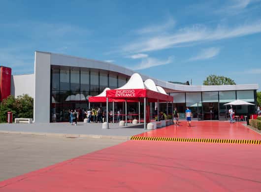 Close-up van een Ferrari stuur en interieur tijdens een tour