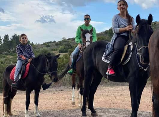 Ruiters op een zandpad met uitzicht op de kust nabij Cagliari