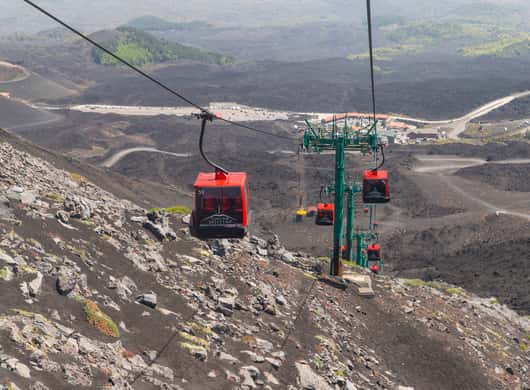 Gids die een groep over een lavaveld op de Etna begeleidt