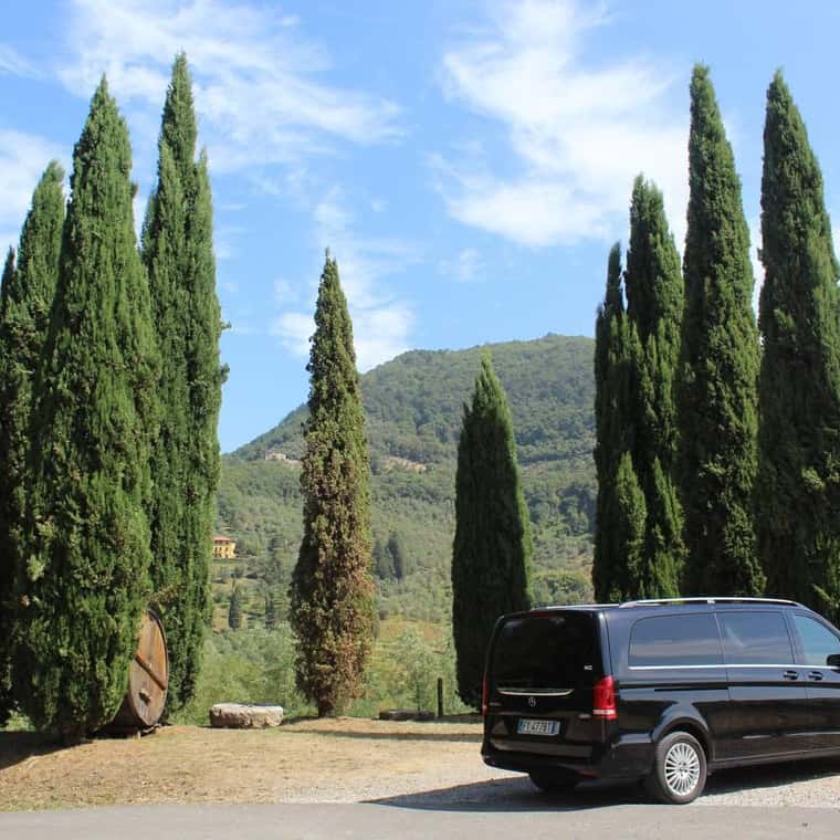 Wijnflessen en glazen op tafel bij Toscaanse wijngaard