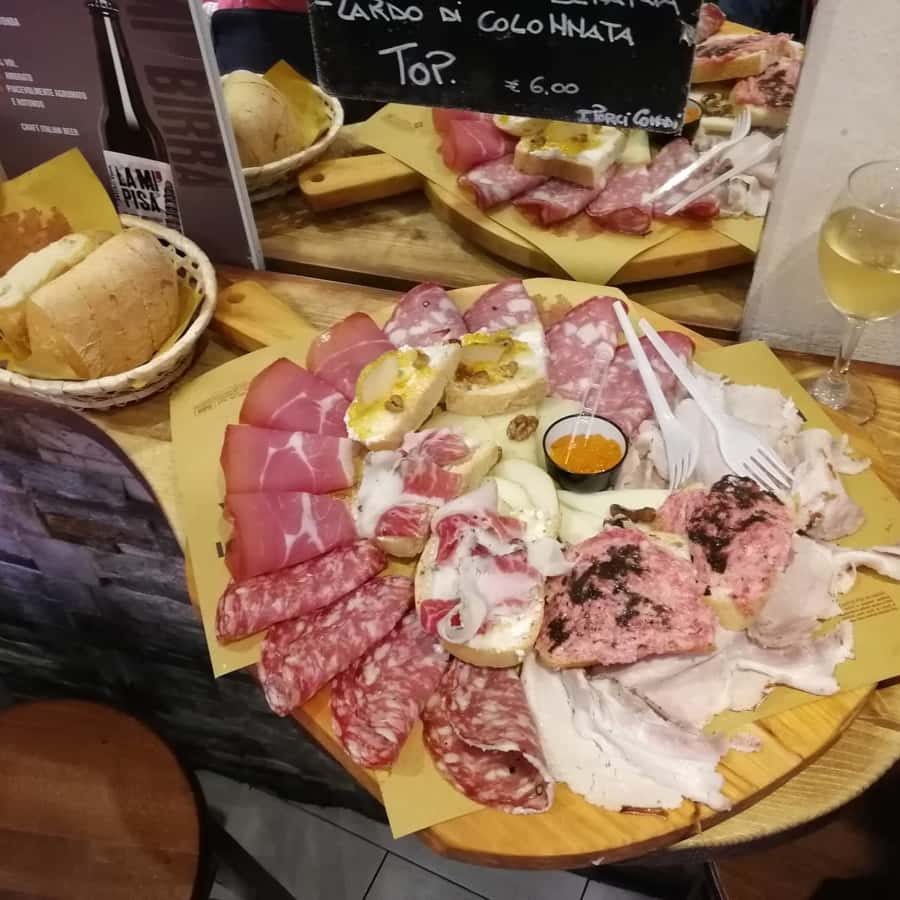 Kleine groep geniet van eten in een lokaal restaurant in Pisa