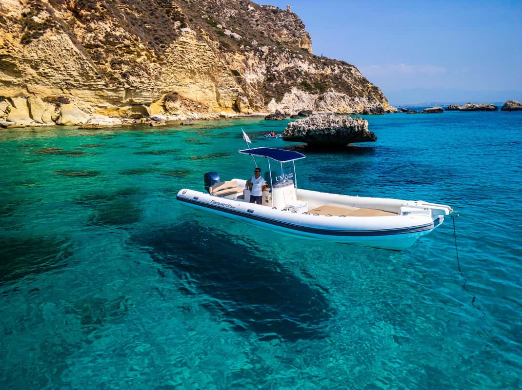 Boot voor de kust van Cagliari tijdens een snorkeltocht met meerdere stops