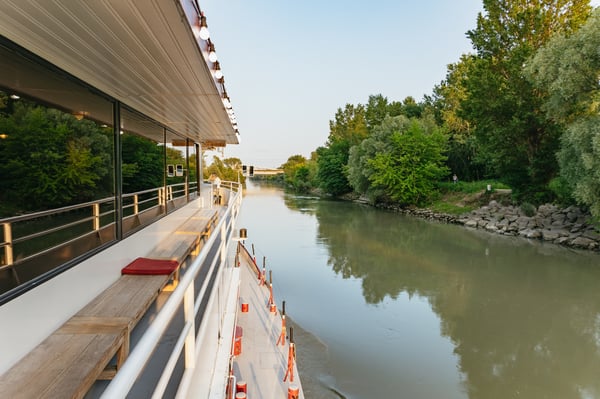 Luxury dinner cruise on the Danube River in Vienna at night with illuminated city skyline and elegant guests. Luxury dinner cruise on the Danube River in Vienna at night with illuminated city skyline and elegant guests.