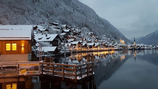Panoramic view of the picturesque village of Hallstatt, Austria, reflecting on a calm alpine lake with mountains at golden hour. Panoramic view of the picturesque village of Hallstatt, Austria, reflecting on a calm alpine lake with mountains at golden hour.