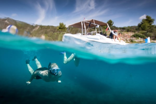 Luxury private speedboat anchored in the turquoise Blue Lagoon near Trogir, Croatia, with passengers swimming in clear water. Luxury private speedboat anchored in the turquoise Blue Lagoon near Trogir, Croatia, with passengers swimming in clear water.