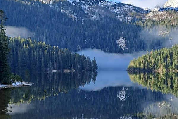Hikers on the trail around Black Lake in Durmitor National Park Montenegro with stunning mountain reflections in clear water Hikers on the trail around Black Lake in Durmitor National Park Montenegro with stunning mountain reflections in clear water