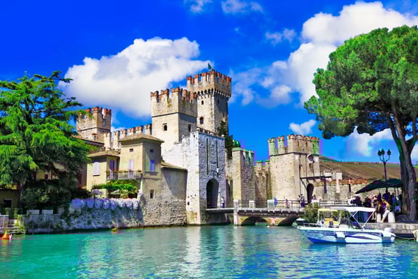 Luxury private boat cruise on Lake Garda, Italy with guests enjoying drinks and panoramic mountain views Luxury private boat cruise on Lake Garda, Italy with guests enjoying drinks and panoramic mountain views