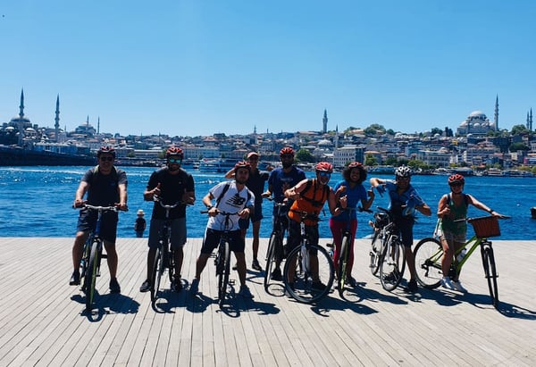 A guided scenic bike tour group enjoying a ride along the Istanbul waterfront with the Bosphorus Bridge in the background. A guided scenic bike tour group enjoying a ride along the Istanbul waterfront with the Bosphorus Bridge in the background.