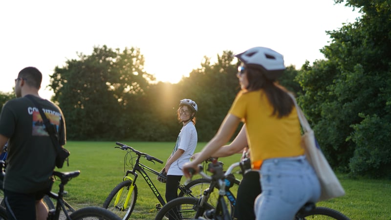 Group of friends on a guided bike tour in Milan's Sempione Park with Sforza Castle in the background Group of friends on a guided bike tour in Milan's Sempione Park with Sforza Castle in the background