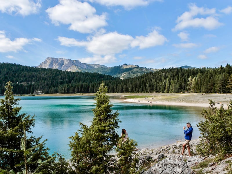 Panoramic aerial view of Montenegro's Bay of Kotor from a cable car, showing the winding fjord-like bay, mountains, and historic towns below. Panoramic aerial view of Montenegro's Bay of Kotor from a cable car, showing the winding fjord-like bay, mountains, and historic towns below.