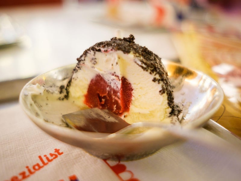 A group enjoying a hidden street food tour at Vienna's Naschmarkt, tasting traditional Austrian pastries and sausages at a vibrant market stall. A group enjoying a hidden street food tour at Vienna's Naschmarkt, tasting traditional Austrian pastries and sausages at a vibrant market stall.