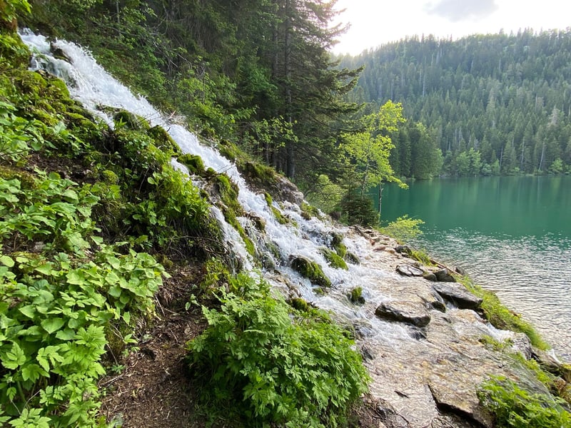 Hiker enjoying a panoramic mountain view of Black Lake in Durmitor National Park, Montenegro Hiker enjoying a panoramic mountain view of Black Lake in Durmitor National Park, Montenegro