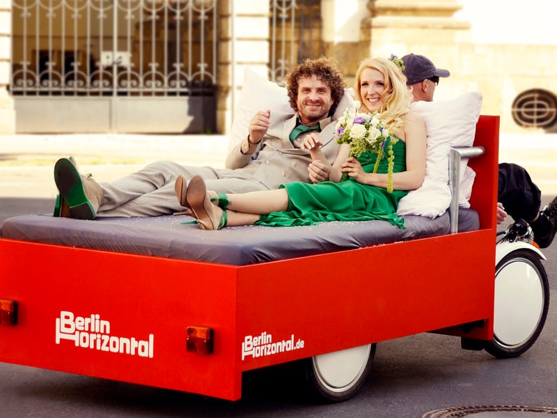 Group of tourists smiling on e-bikes during a guided tour in front of the Brandenburg Gate in Berlin Group of tourists smiling on e-bikes during a guided tour in front of the Brandenburg Gate in Berlin