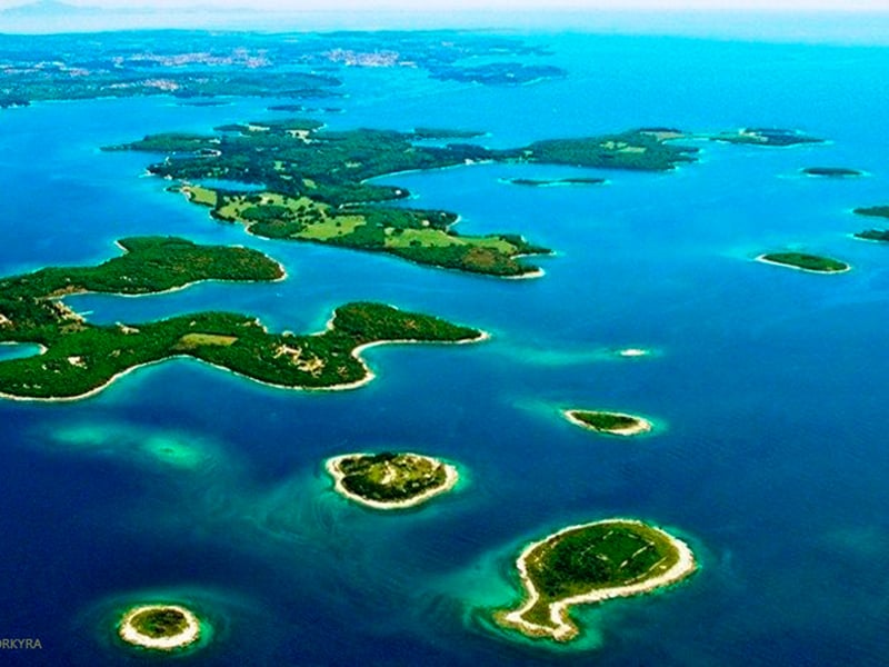 Aerial view of a boat tour in Brijuni National Park near Pula, Croatia, showing turquoise water and green islands. Aerial view of a boat tour in Brijuni National Park near Pula, Croatia, showing turquoise water and green islands.