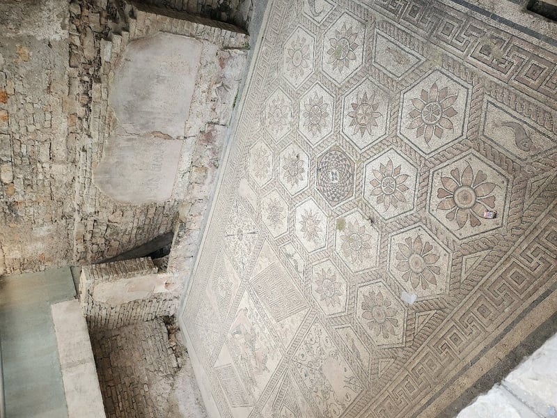 A guided walking tour group explores the ancient Roman Arena in Pula, Croatia, under a bright blue sky. A guided walking tour group explores the ancient Roman Arena in Pula, Croatia, under a bright blue sky.