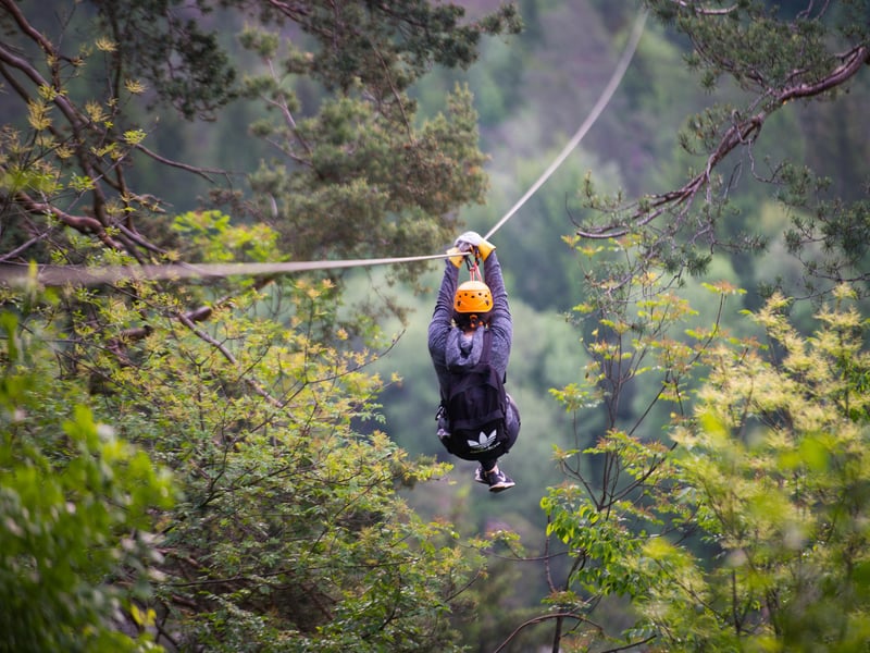 Two adventurers ziplining together over the emerald Sava Dolinka River in Bled, Slovenia with mountain panorama Two adventurers ziplining together over the emerald Sava Dolinka River in Bled, Slovenia with mountain panorama