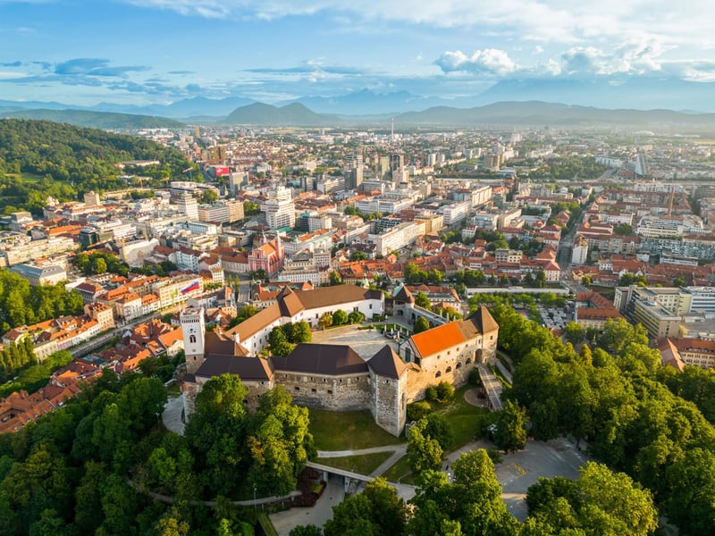 A guided walking tour group on Ljubljana's Triple Bridge with the castle in the background, showcasing the city's charm. A guided walking tour group on Ljubljana's Triple Bridge with the castle in the background, showcasing the city's charm.