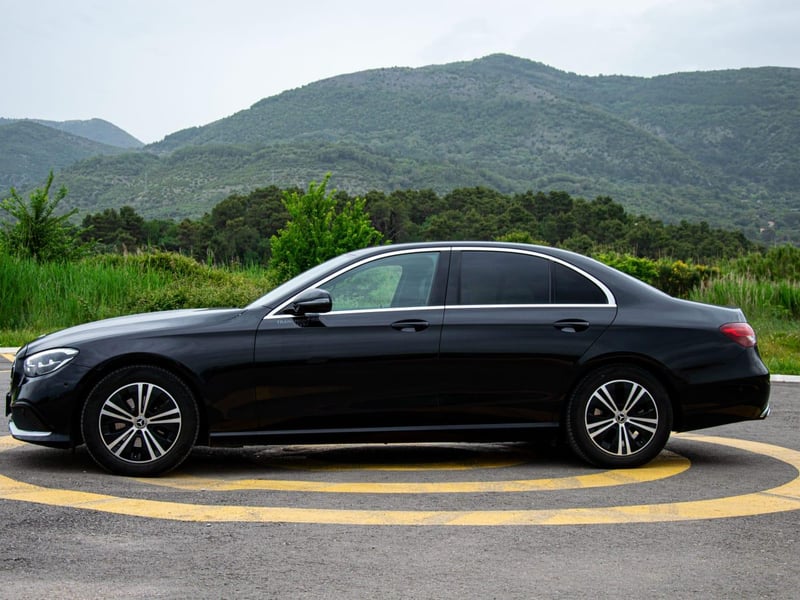 Luxury private transfer van on scenic coastal road to Budva, Montenegro with sea and mountain views Luxury private transfer van on scenic coastal road to Budva, Montenegro with sea and mountain views