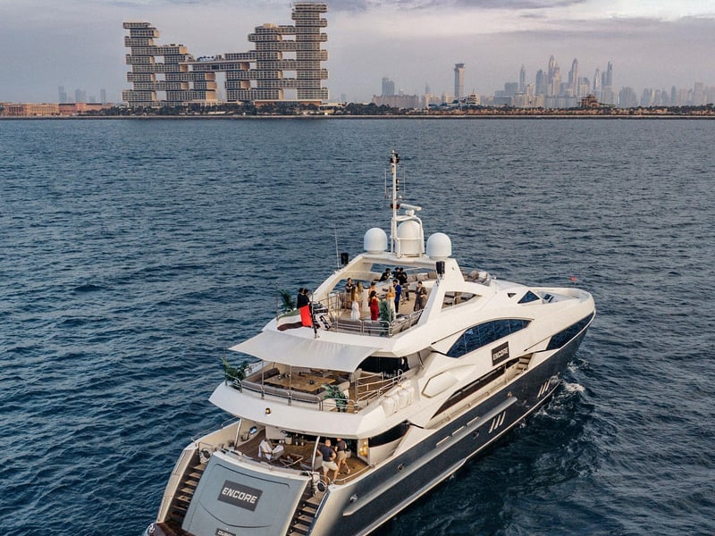Luxury Sunseeker superyacht cruising in Dubai Marina at sunset with guests and iconic skyline view Luxury Sunseeker superyacht cruising in Dubai Marina at sunset with guests and iconic skyline view