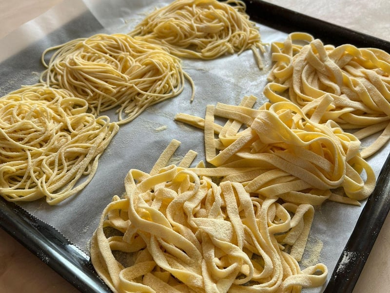 A family enjoying a cooking class in Venice, learning to make fresh pasta with a local chef in a traditional kitchen. A family enjoying a cooking class in Venice, learning to make fresh pasta with a local chef in a traditional kitchen.