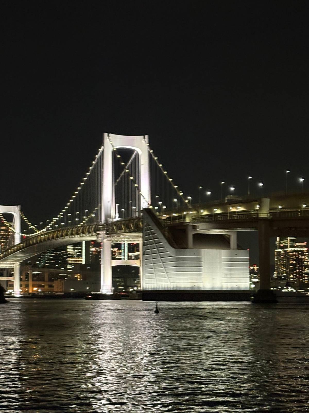 Rainbow Bridge lit white over Tokyo Bay