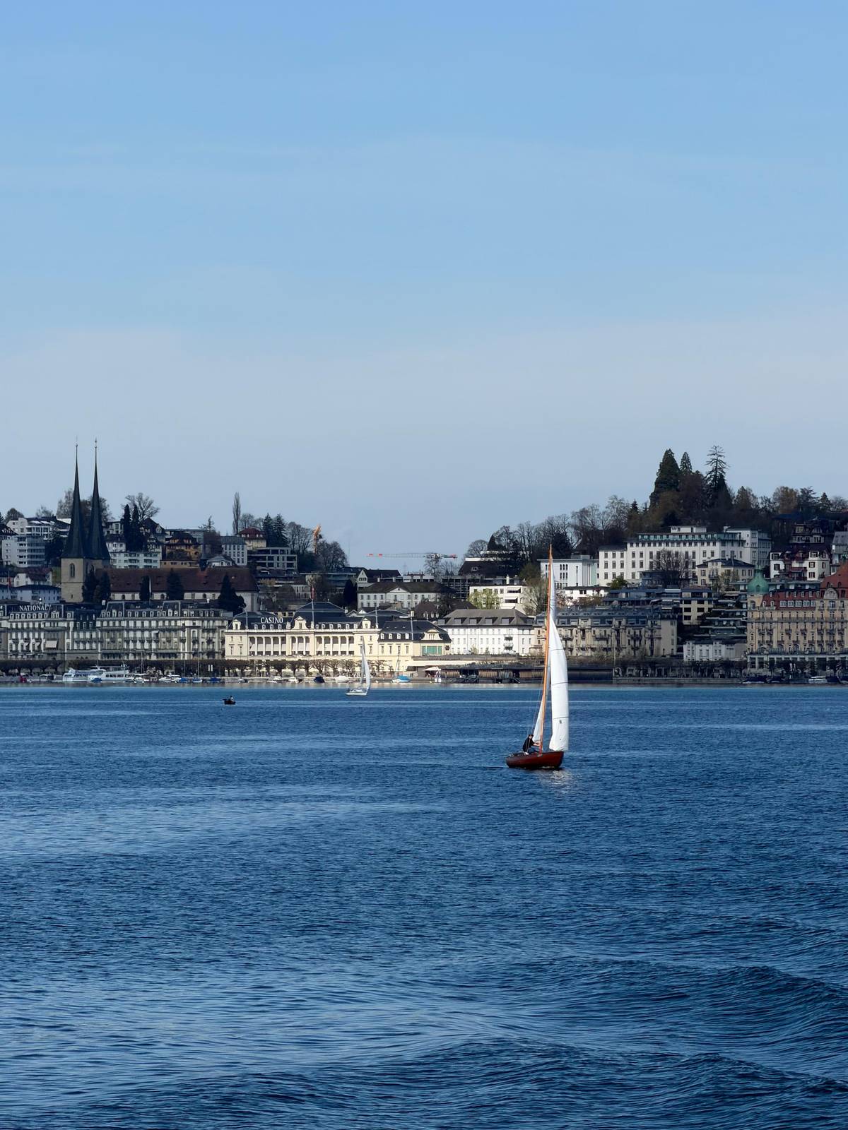The towers of Lucerne behind a sailing boat