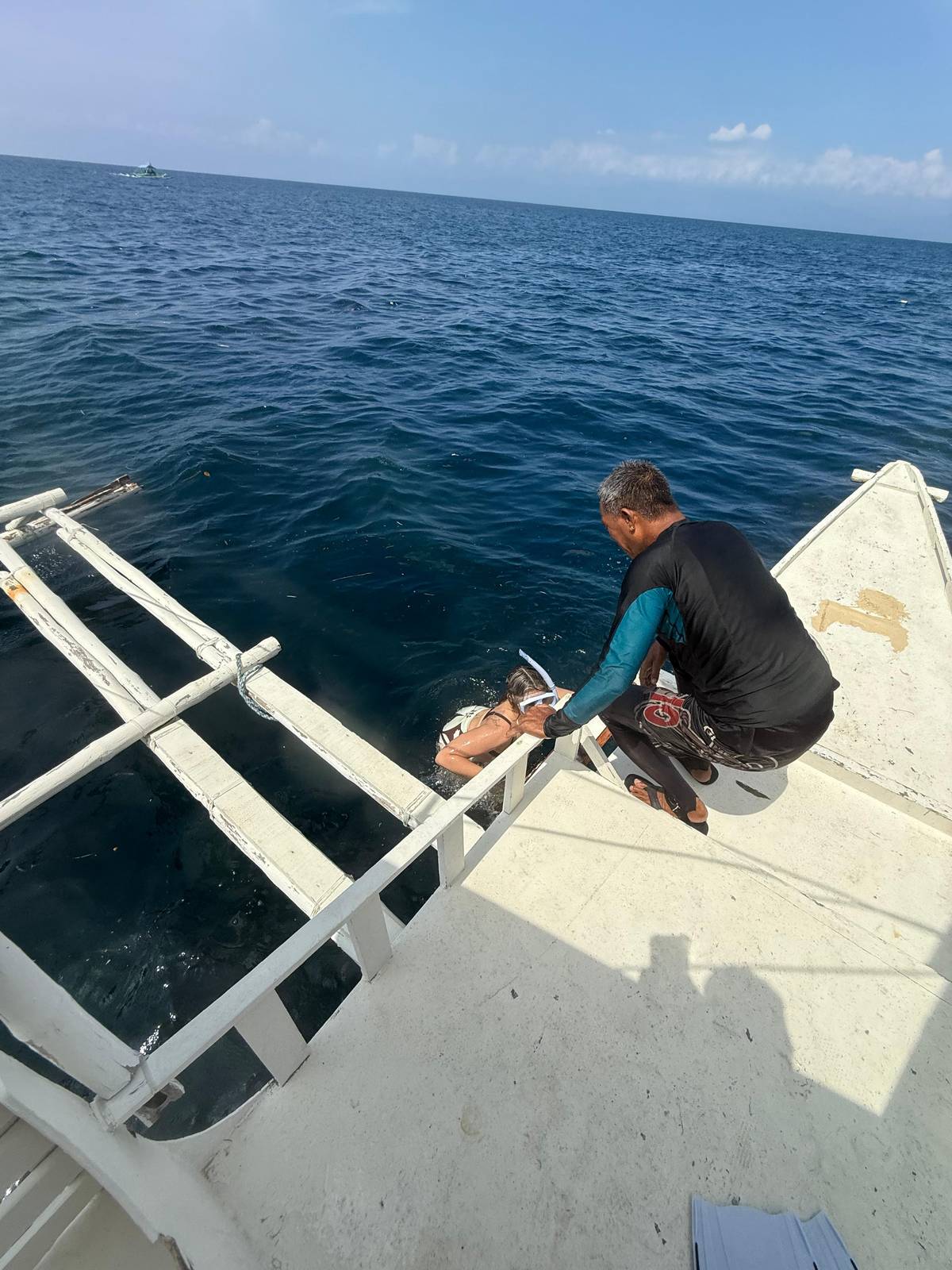 A crewman at the bow of an outrigger