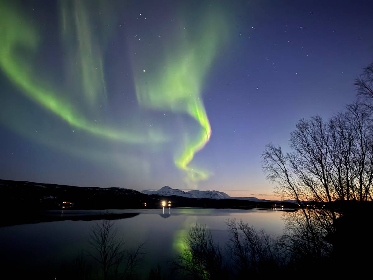 Nordlicht über einem See in der Dämmerung