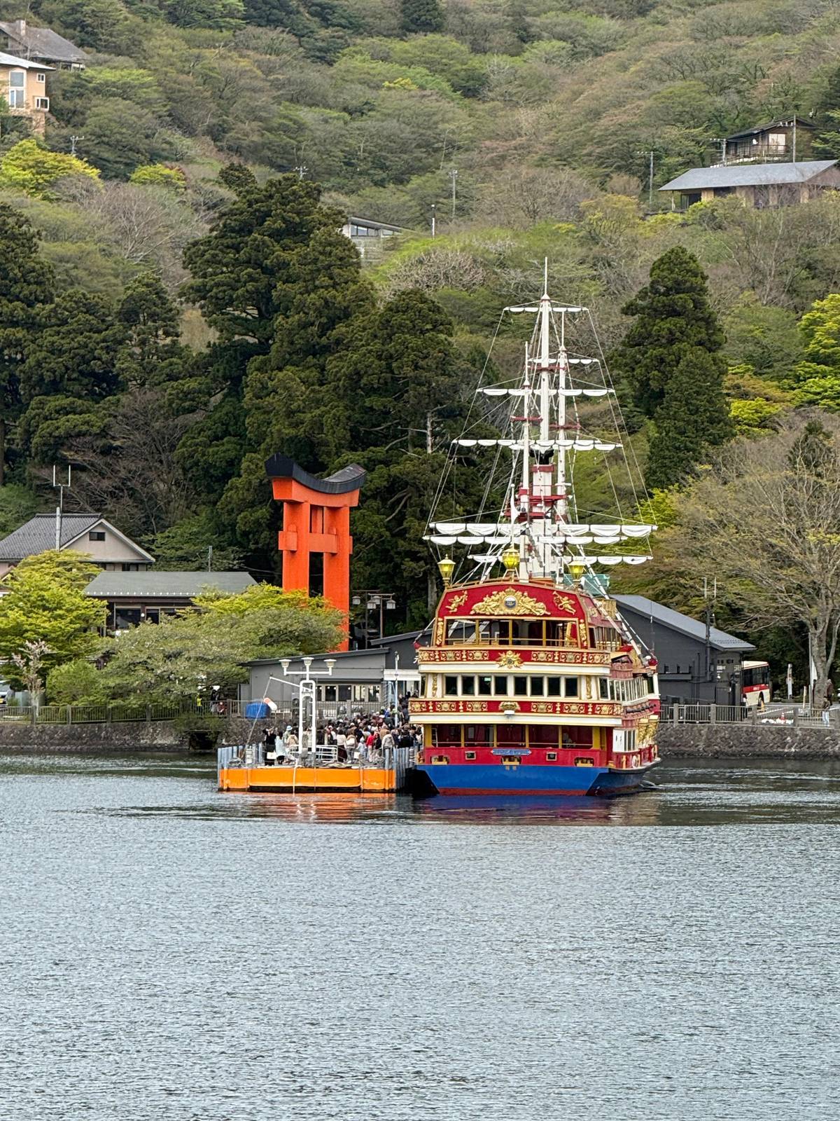 A pirate ship docking beside the red torii at Moto-Hakone