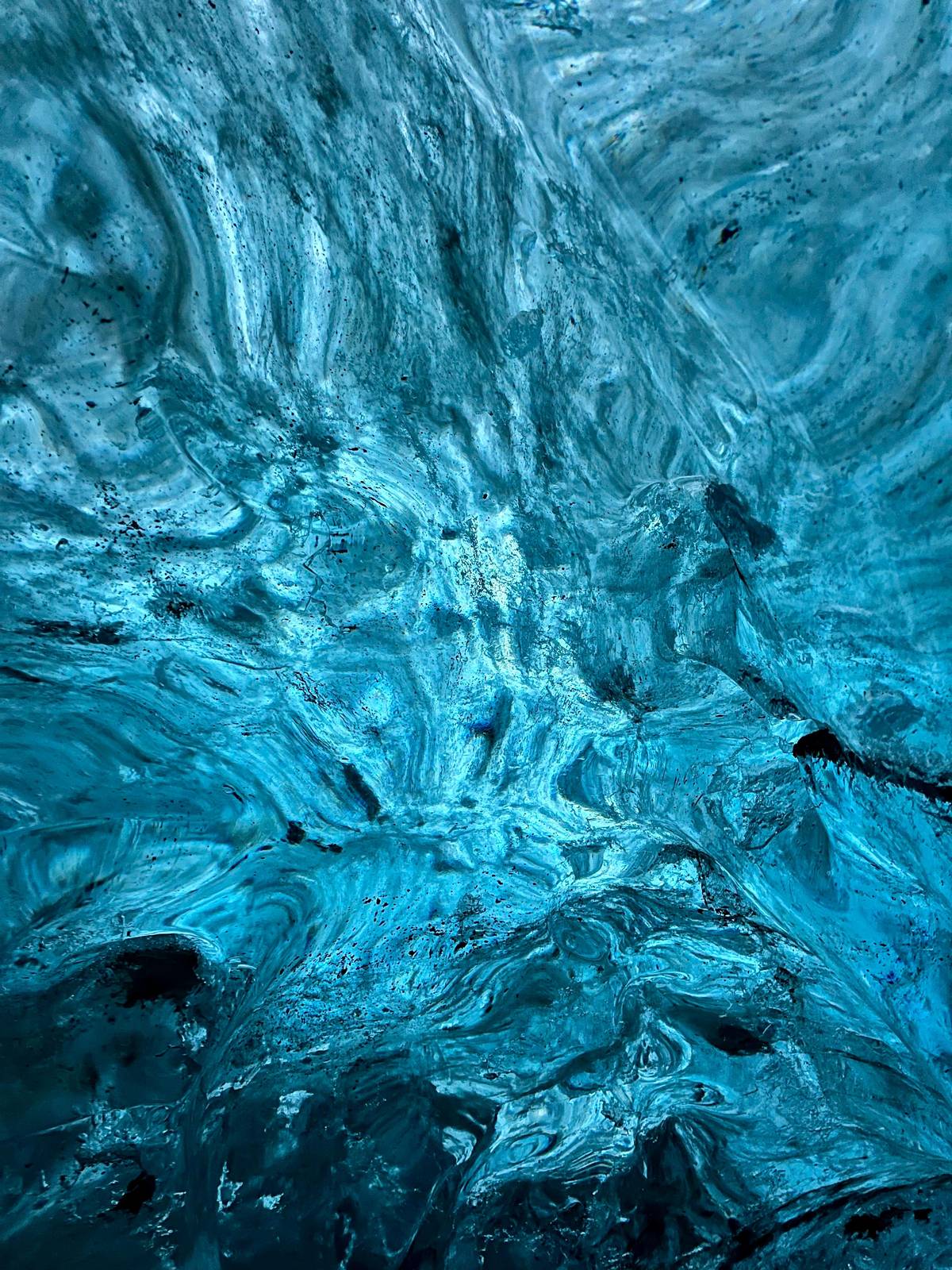 Close view of blue glacier ice with trapped bubbles