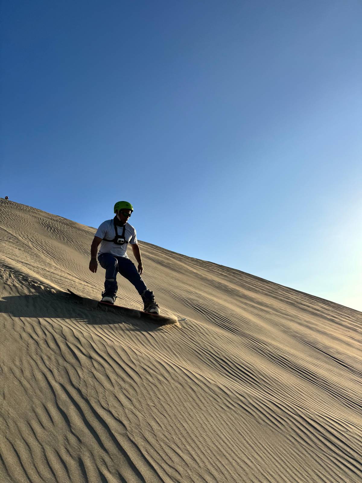 A rider standing on a board on a steep sandy slope