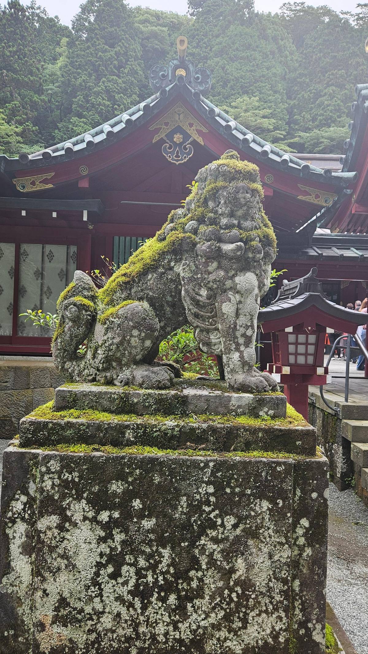 A moss-covered guardian lion at a shrine