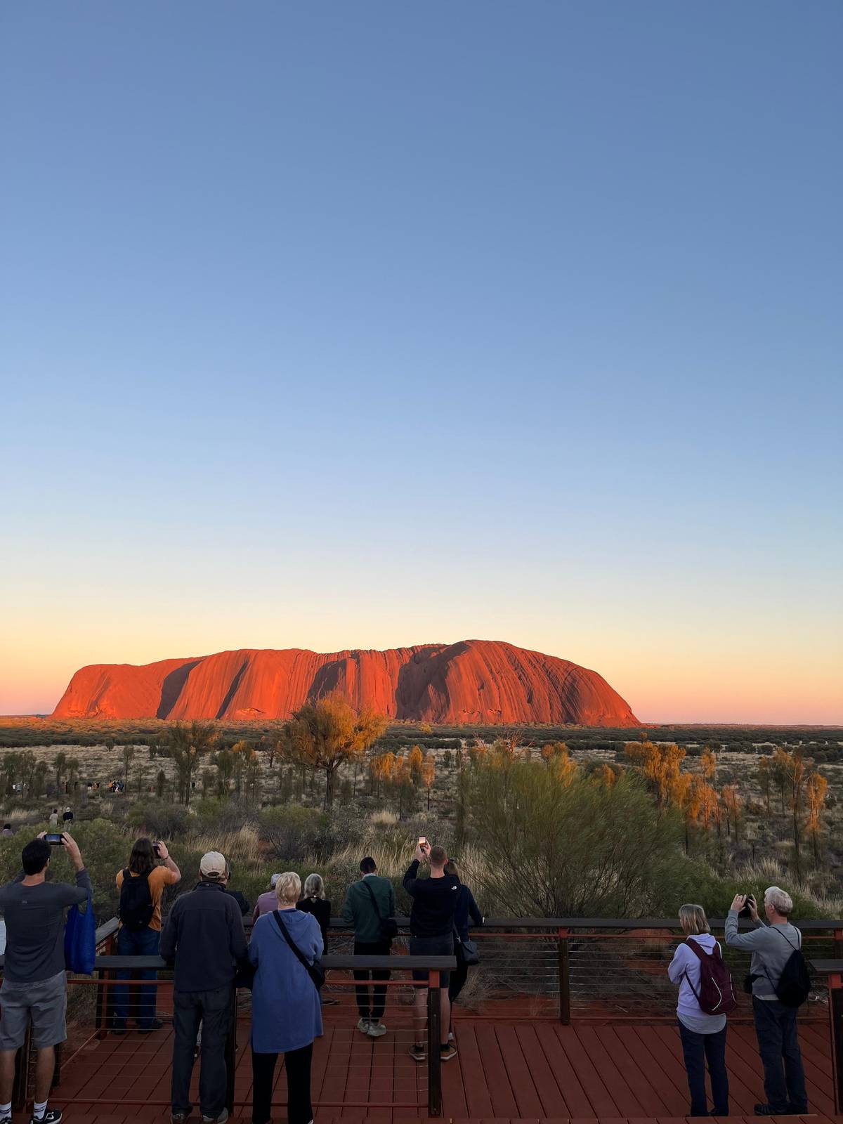 Guests on the viewing platform as the rock turns red at dawn