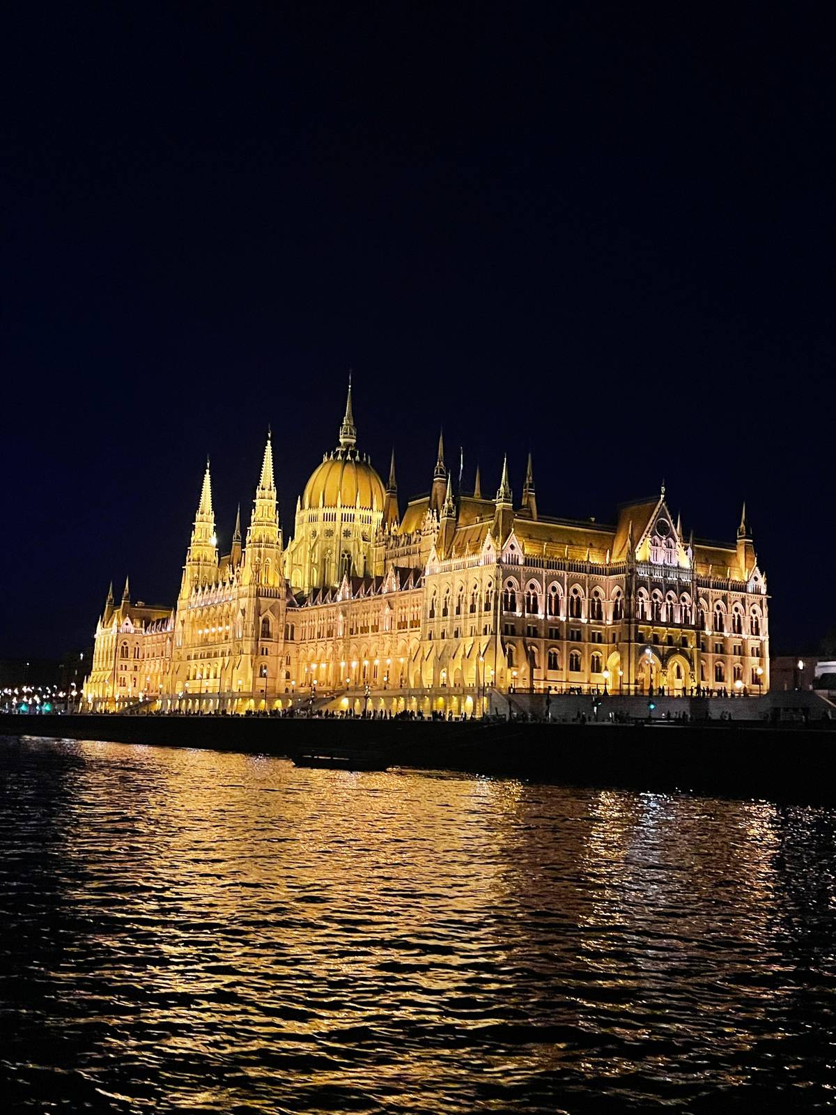 The Parliament lit gold across the Danube at night