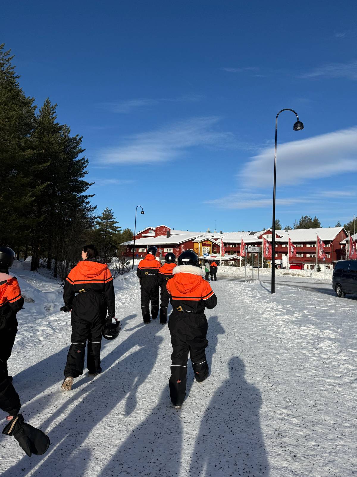 Guests in overalls walking to the snowmobiles in the village