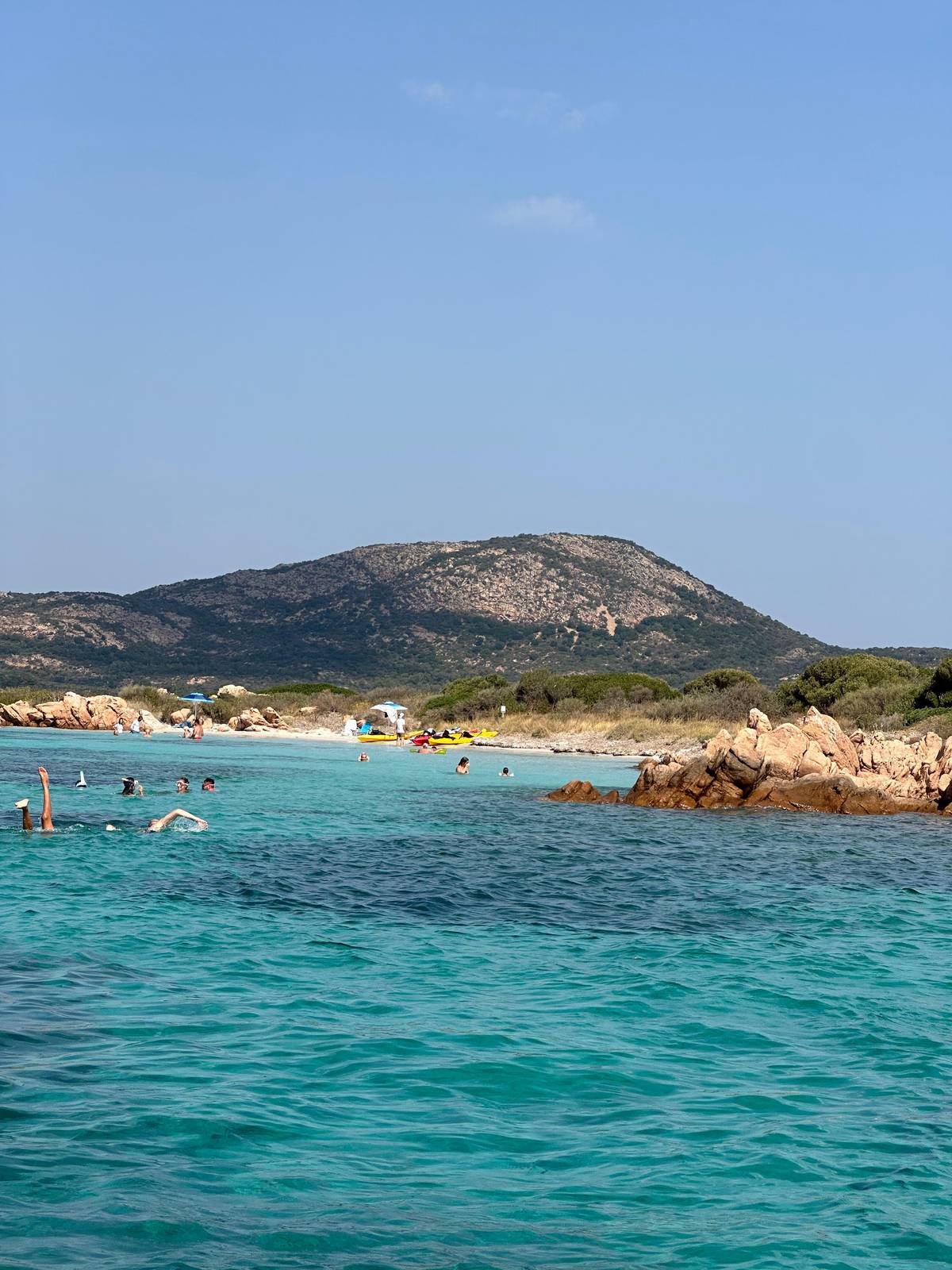 Swimmers in a cove between granite rocks